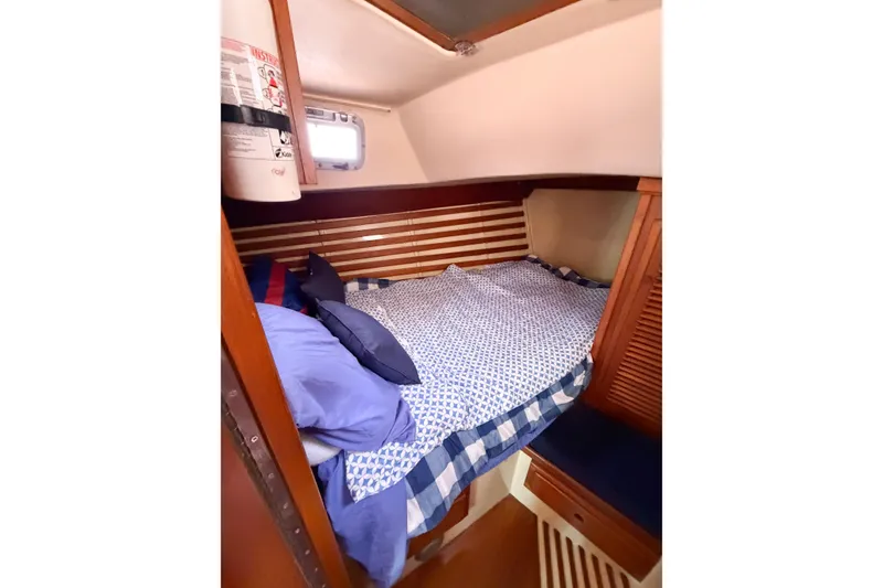 Slide: The Image of Cozy cabin interior of 1987 Bayfield 36 sailboat with striped bedding and wooden accents. - 52
