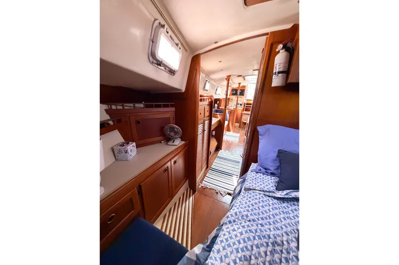 Slide: The Image of Interior of a 1987 Bayfield 36 sailboat, featuring cozy wooden cabinetry and a comfortable sleeping area. - 55