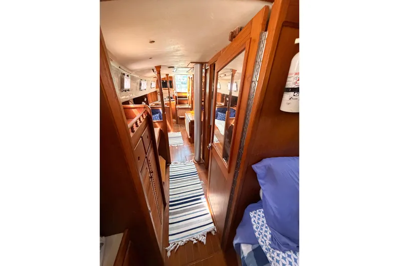 Slide: The Image of Interior of a 1987 Bayfield 36 sailboat with wooden finishes and striped rugs. - 56