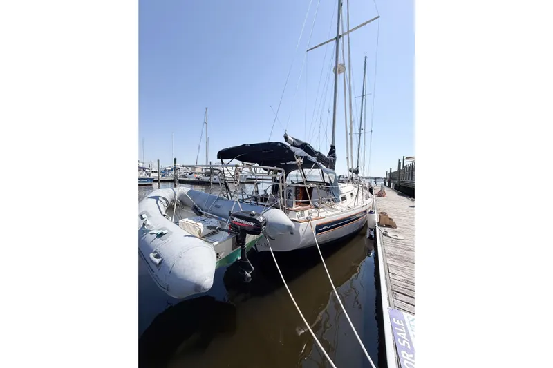 Slide: The Image of 1987 Bayfield 36 sailboat docked with inflatable dinghy, clear sky background. - 6