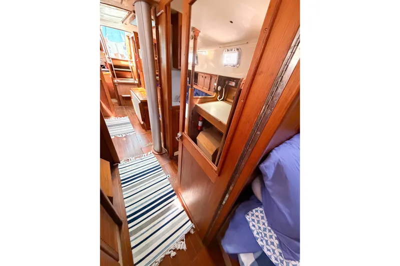Slide: The Image of Interior of 1987 Bayfield 36 sailboat with wooden finish and striped rugs. - 60