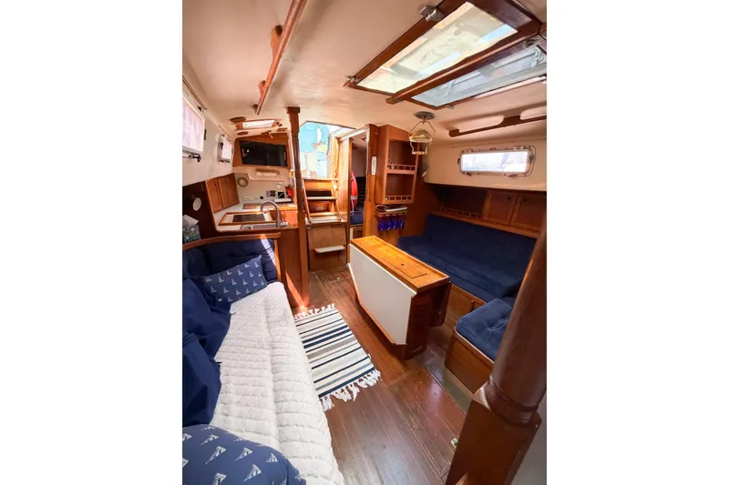 Slide: The Image of Interior of a 1987 Bayfield 36 sailboat, featuring cozy seating and wooden finishes. - 61