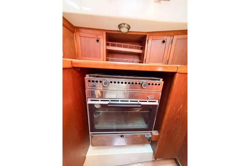 Slide: The Image of 1987 Bayfield 36 yacht kitchen with wooden cabinets and stainless steel oven. - 62