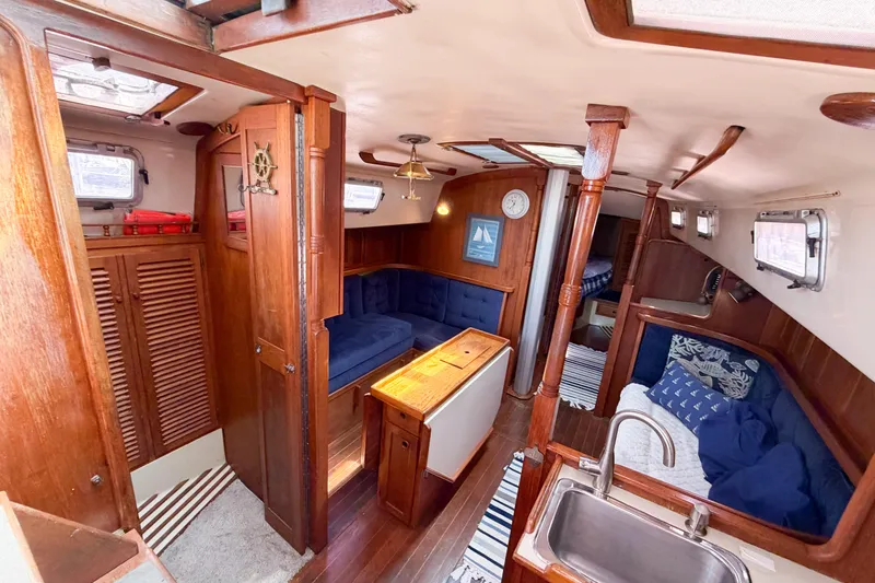 Slide: The Image of Interior of a 1987 Bayfield 36 sailboat with wooden finishes and cozy seating area. - 63