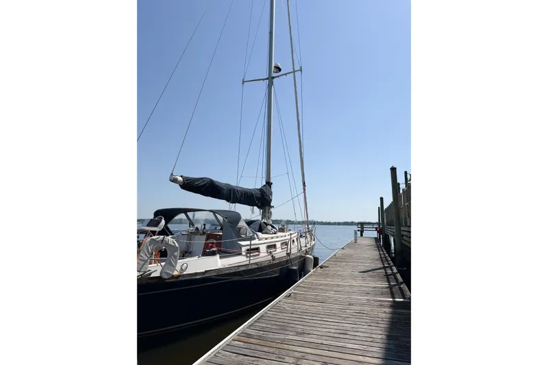 Slide: The Image of Sailboat Bayfield 36, 1987 model, docked at a wooden pier under clear blue sky. - 7