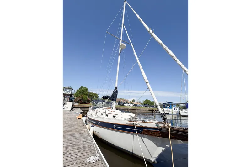 Slide: The Image of 1987 Bayfield 36 sailboat docked at a marina under clear blue skies. - 8