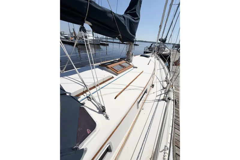 Slide: The Image of 1987 Bayfield 36 sailboat docked, showcasing deck and rigging details. - 9