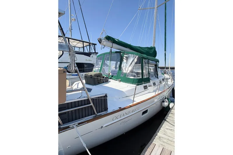 Slide: The Image of 2002 Beneteau Oceanis 42CC sailboat docked, featuring green canopy and sleek design. - 10