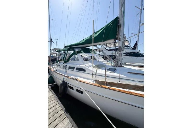Slide: The Image of 2002 Beneteau Oceanis 42CC sailboat docked, featuring green canopy and sleek white hull. - 11
