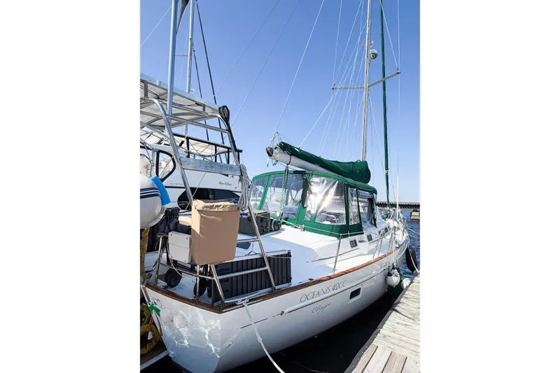 Slide: The Image of 2002 Beneteau Oceanis 42CC sailboat docked, featuring green sail cover and spacious deck. - 13
