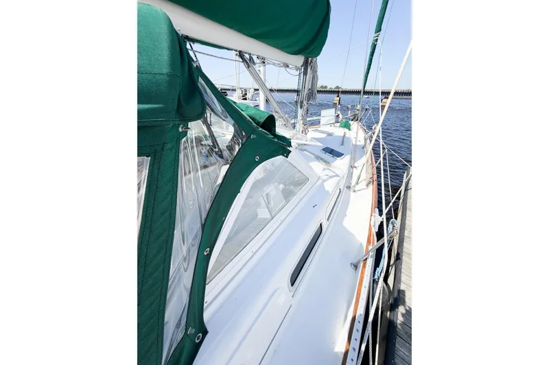 Slide: The Image of 2002 Beneteau Oceanis 42CC sailboat docked, featuring green canopy and sleek white deck. - 14