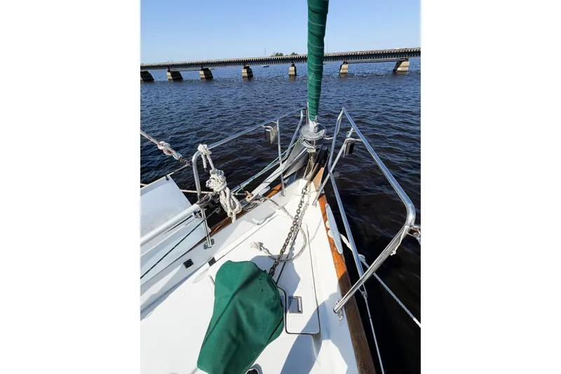 Slide: The Image of Bow of 2002 Beneteau Oceanis 42CC sailboat with anchor chain, docked near a bridge. - 15