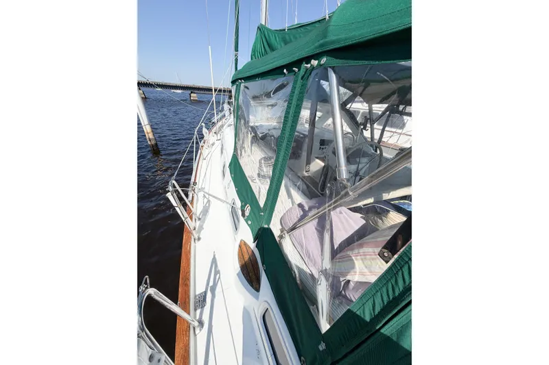 Slide: The Image of Beneteau Oceanis 42CC sailboat, 2002 model, with green canopy, docked on calm water. - 26