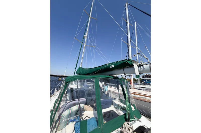 Slide: The Image of 2002 Beneteau Oceanis 42CC sailboat with green canopy, docked under clear blue sky. - 27