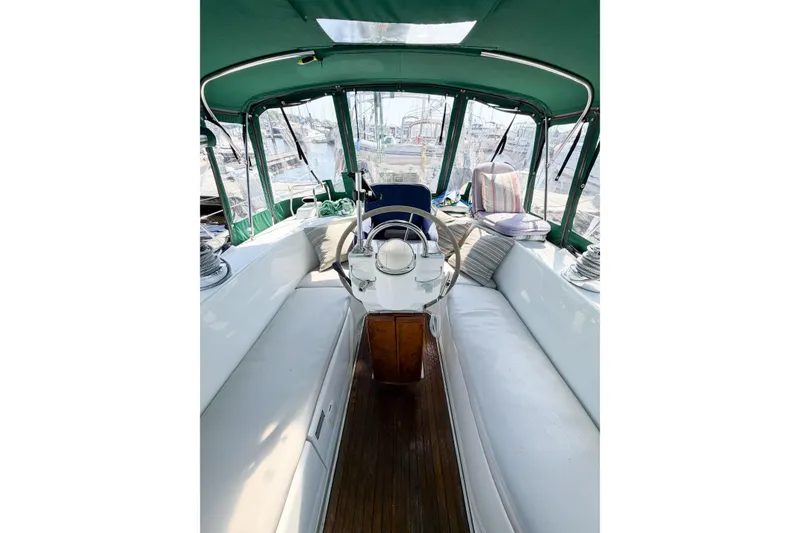 Slide: The Image of Interior view of 2002 Beneteau Oceanis 42CC sailboat cockpit with white seating and green canopy. - 28