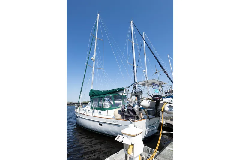 Slide: The Image of Sailboat Beneteau Oceanis 42CC 2002 docked, featuring green canopy and dual masts under clear sky. - 3
