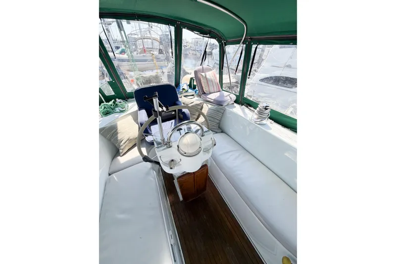 Slide: The Image of Cockpit of 2002 Beneteau Oceanis 42CC sailboat with white seating and green canopy. - 36