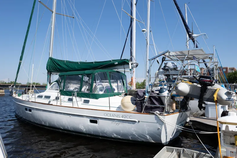 Slide: The Image of 2002 Beneteau Oceanis 42CC sailboat docked, featuring green canopy and sleek design. - 4