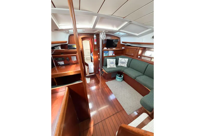 Slide: The Image of Interior of 2002 Beneteau Oceanis 42CC sailboat with wood finish and green seating. - 41