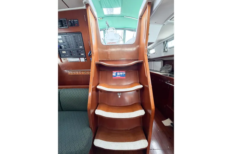 Slide: The Image of Interior view of 2002 Beneteau Oceanis 42CC sailboat, featuring wooden stairs and control panel. - 45