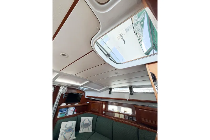 Slide: The Image of Interior of 2002 Beneteau Oceanis 42CC sailboat, featuring cozy seating and overhead hatch. - 46