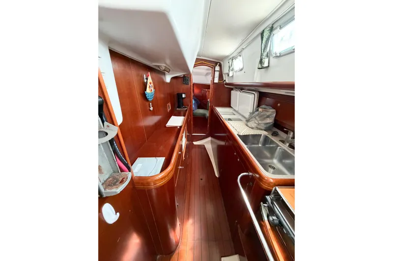 Slide: The Image of Interior of 2002 Beneteau Oceanis 42CC sailboat, featuring a sleek wooden galley design. - 47