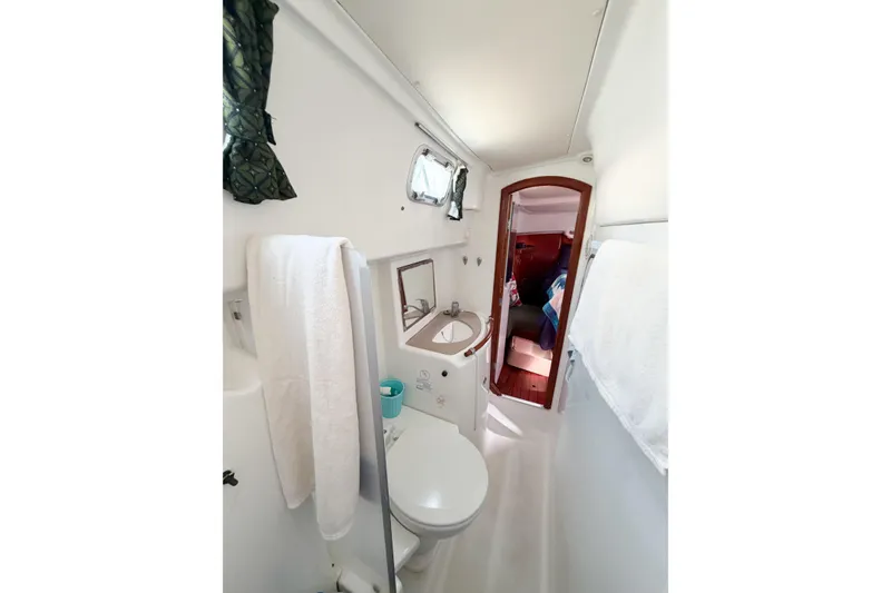 Slide: The Image of Bathroom interior of 2002 Beneteau Oceanis 42CC yacht, featuring sink, toilet, and wooden door. - 56