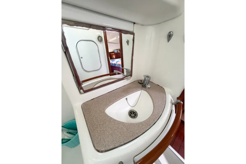 Slide: The Image of Bathroom sink area in 2002 Beneteau Oceanis 42CC yacht, featuring mirror and faucet. - 58
