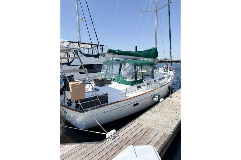 Slide: The Image of 2002 Beneteau Oceanis 42CC sailboat docked at marina, featuring green canopy. - 6
