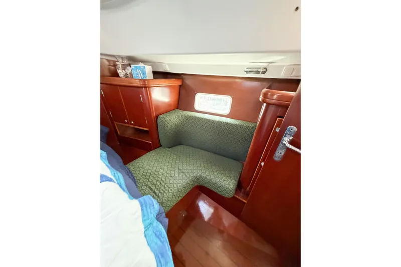 Slide: The Image of Cozy cabin interior of 2002 Beneteau Oceanis 42CC with wooden cabinetry and cushioned seating. - 60