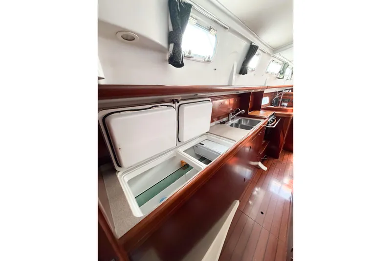 Slide: The Image of Interior view of 2002 Beneteau Oceanis 42CC yacht kitchen with wooden cabinetry and appliances. - 62