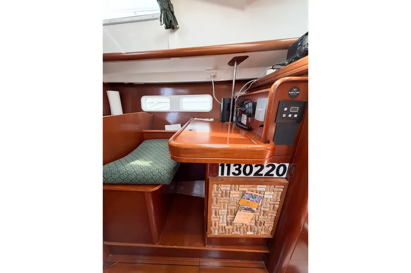 Slide: The Image of Interior of 2002 Beneteau Oceanis 42CC sailboat with navigation station and seating area. - 63