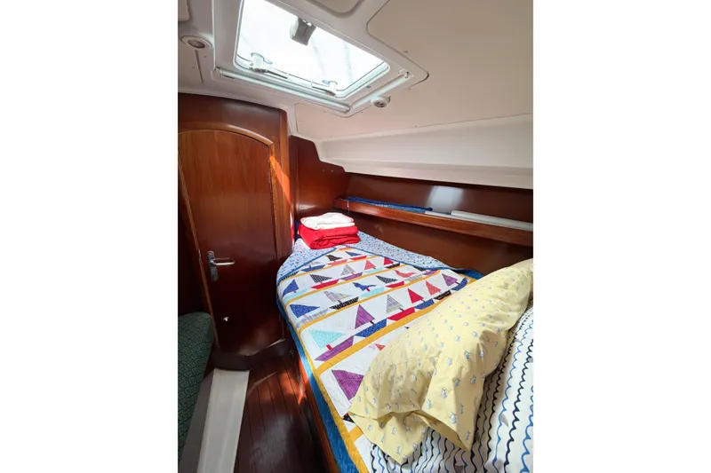 Slide: The Image of Cozy cabin interior of 2002 Beneteau Oceanis 42CC with colorful bedding and skylight. - 65