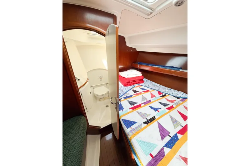 Slide: The Image of Cozy cabin interior of 2002 Beneteau Oceanis 42CC with colorful bedding and adjacent bathroom. - 66