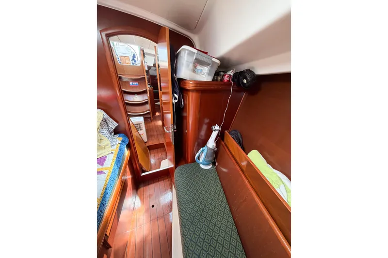 Slide: The Image of Interior of 2002 Beneteau Oceanis 42CC sailboat, featuring wooden cabinetry and cozy seating area. - 67