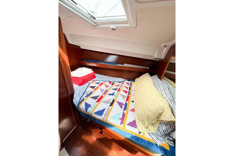 Slide: The Image of Cozy cabin interior of 2002 Beneteau Oceanis 42CC with colorful bedding and skylight. - 68