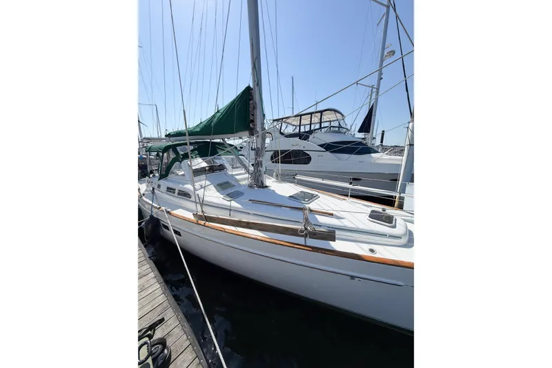 Slide: The Image of 2002 Beneteau Oceanis 42CC sailboat docked, featuring sleek design and green canopy. - 7