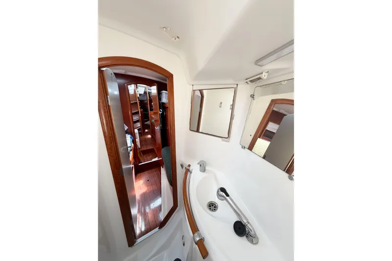 Slide: The Image of Interior view of 2002 Beneteau Oceanis 42CC sailboat bathroom with wooden accents. - 74
