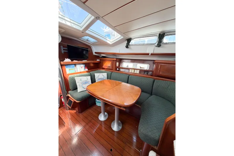 Slide: The Image of Interior of 2002 Beneteau Oceanis 42CC sailboat with cozy seating and wooden table. - 77