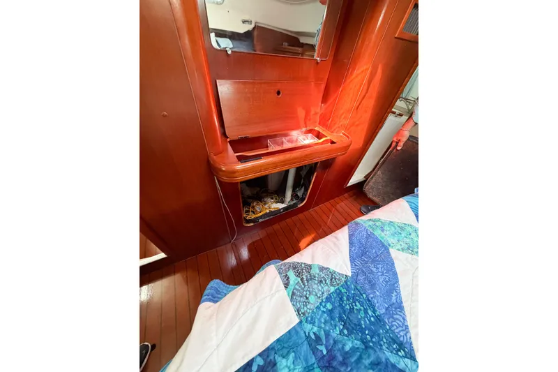 Slide: The Image of Interior of 2002 Beneteau Oceanis 42CC yacht with wooden cabinetry and colorful quilt. - 83
