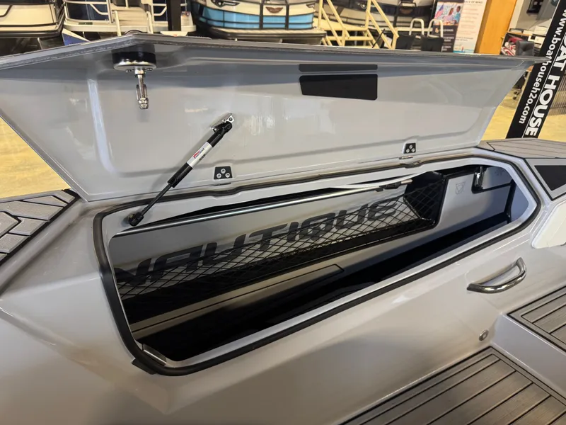 Slide: The Image of 2025 Nautique Ski boat with open storage compartment lid. - 15
