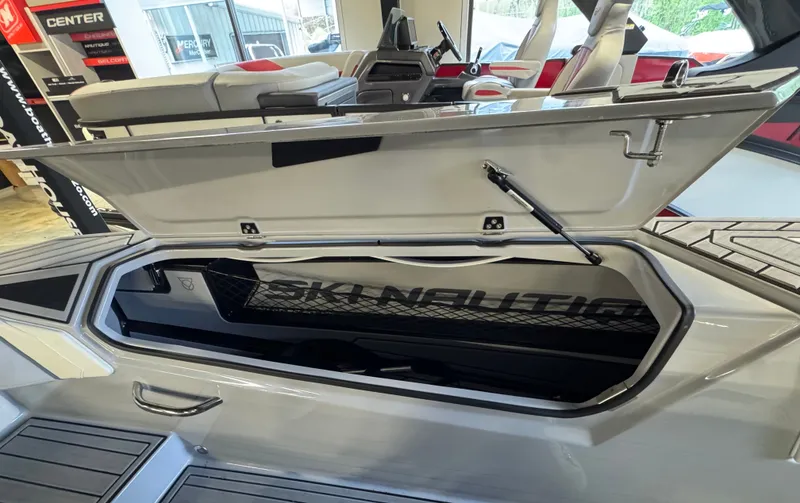 Slide: The Image of 2025 Nautique Ski boat with open storage compartment. - 16