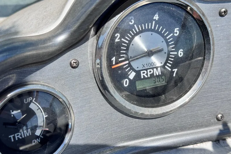 Slide: The Image of 2022 NauticStar 223DC Sport Deck boat with canopy, docked under a cloudy sky. - 10