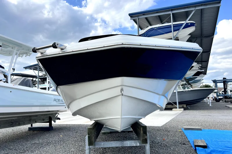 Slide: The Image of 2022 NauticStar 223DC Sport Deck boat on display under a cloudy sky. - 17