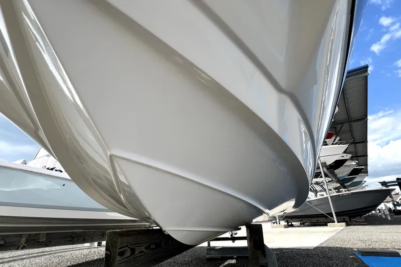 Slide: The Image of 2022 NauticStar 223DC Sport Deck boat hull on display under clear sky. - 22