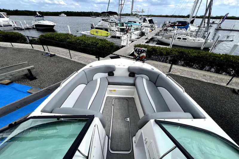 Slide: The Image of 2022 NauticStar 223DC Sport Deck boat docked at marina with spacious seating. - 28