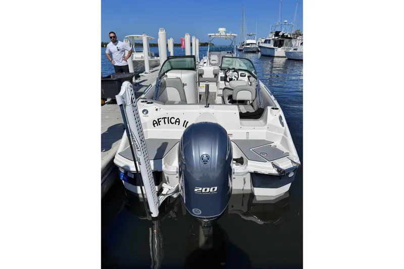 Slide: The Image of 2022 NauticStar 223DC Sport Deck boat with Yamaha engine, black canopy, and seating. - 3