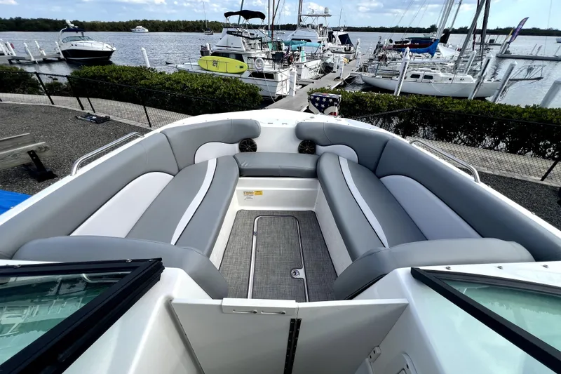 Slide: The Image of 2022 NauticStar 223DC Sport Deck boat with spacious seating, docked at a marina. - 30