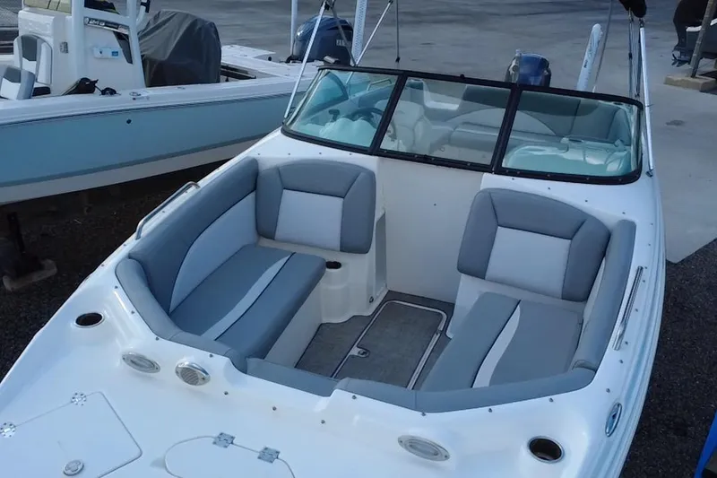 Slide: The Image of 2022 NauticStar 223DC Sport Deck boat with gray seating and windshield. - 34