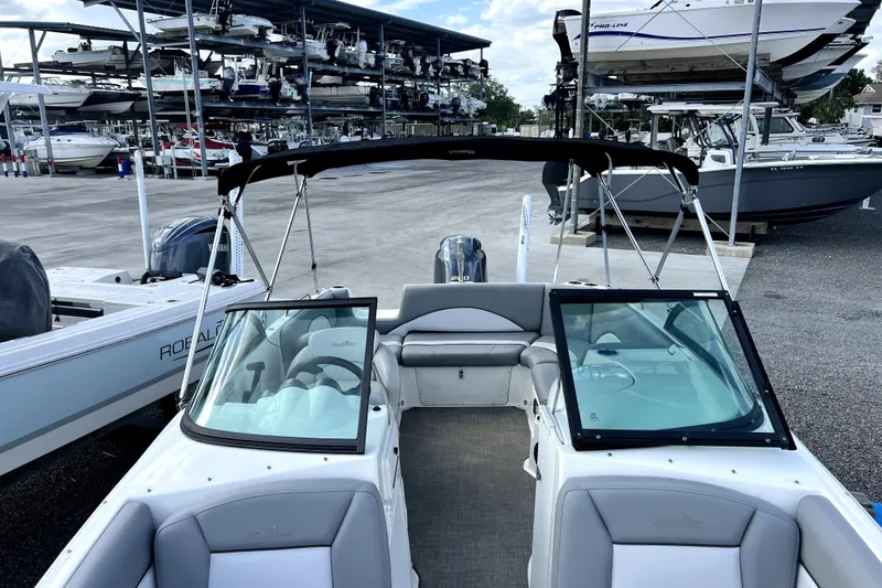 Slide: The Image of 2022 NauticStar 223DC Sport Deck boat in marina storage, featuring sleek design and spacious seating. - 39
